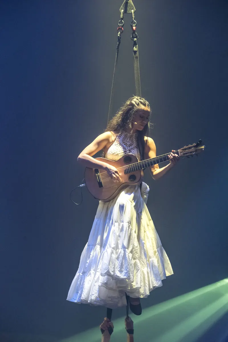 Mamselle Ruiz suspendue dans les airs, guitare à la main
