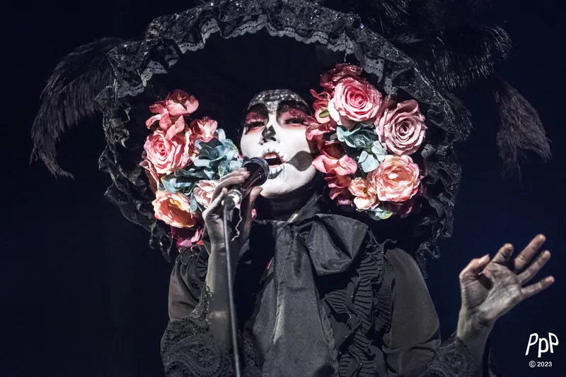 Mamselle Ruiz en Catrina au micro, grand chapeau de fleurs