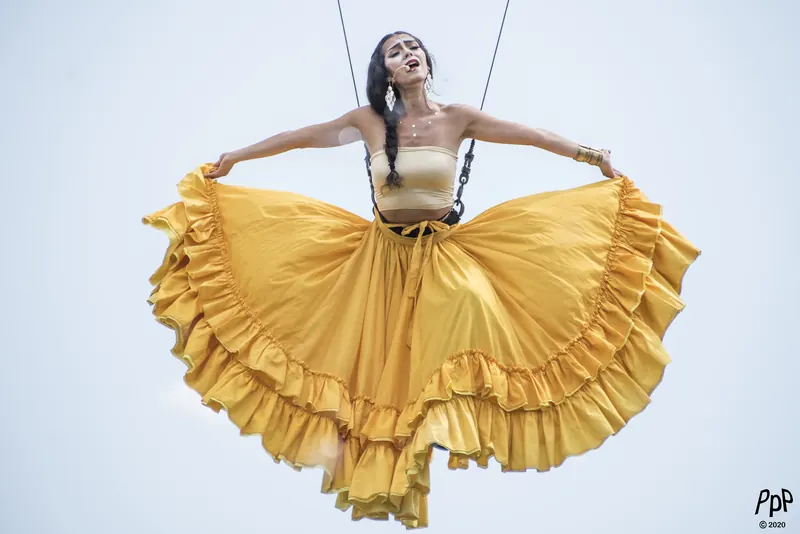 Mamselle Ruiz suspendue dans le ciel, grande jupe jaune déployée