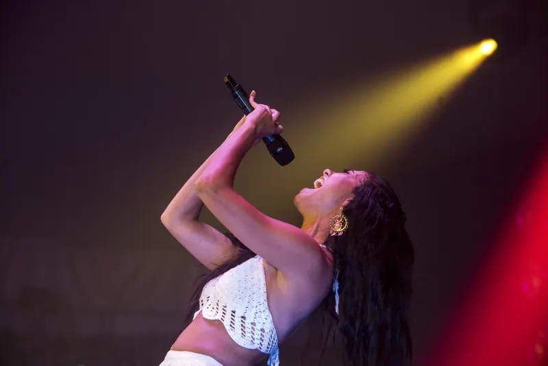 Mamselle Ruiz chante, micro levé, dans un faisceau doré